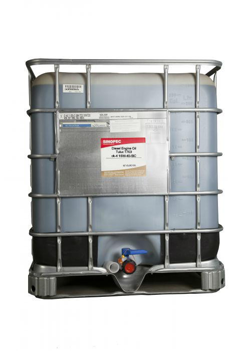 A large IBC (Intermediate Bulk Container) filled with diesel engine oil, featuring a label with product information.